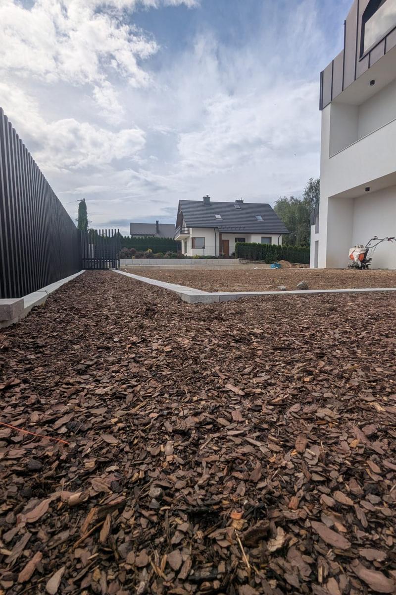 Przygotowana rabata ze ściółką z kory, oświetleniem i nawadnianiem